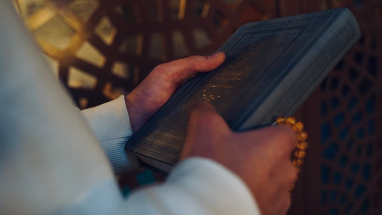 A Person Holding a Koran